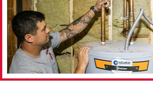 A pickup truck and trailer with plumbers working on a water main in the middle of the street.